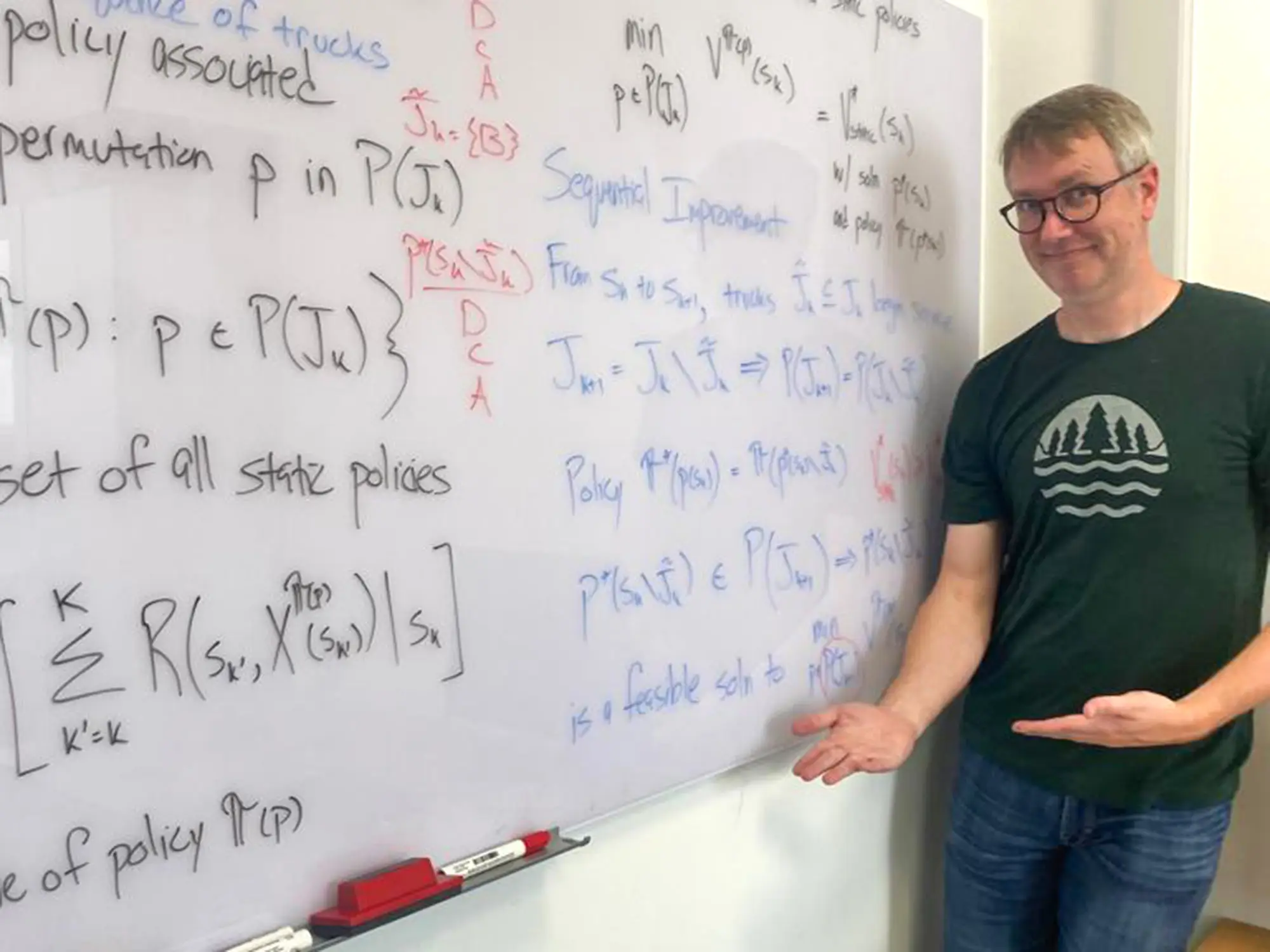 Justin Goodson at a whiteboard full of equations